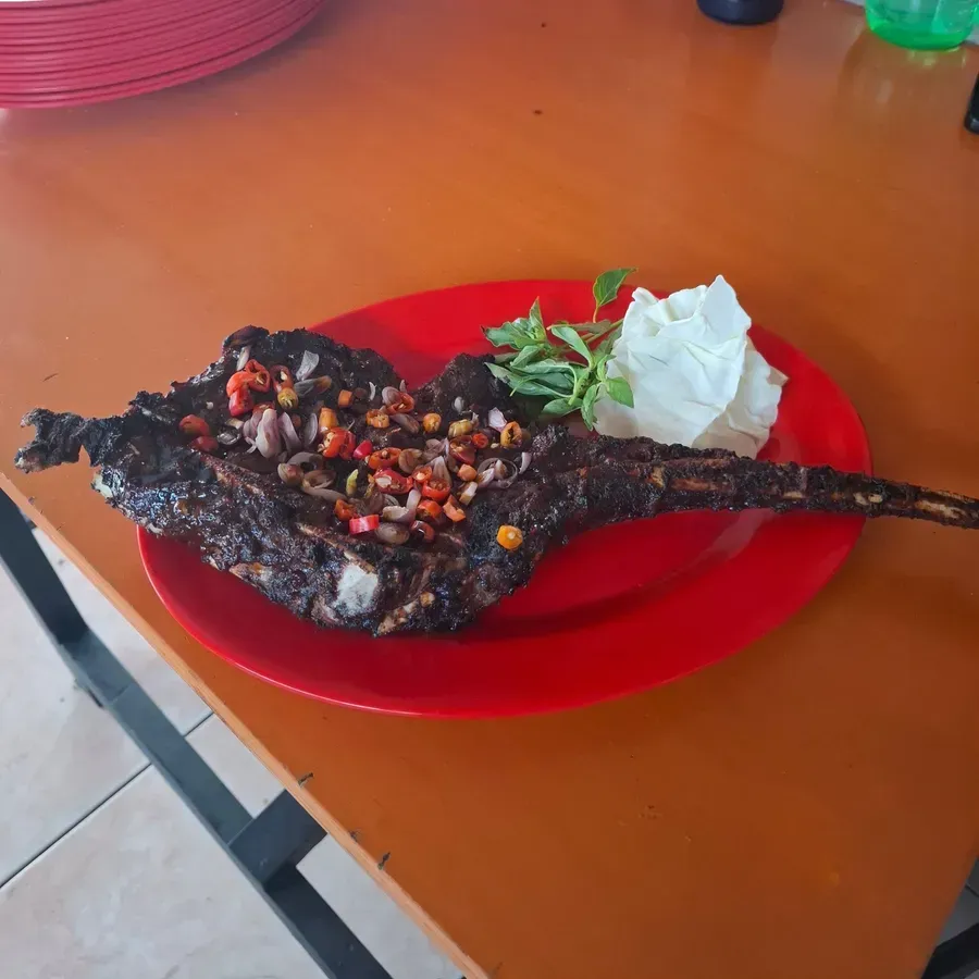 Iga Tomahawk bakar bertulang panjang di piring merah