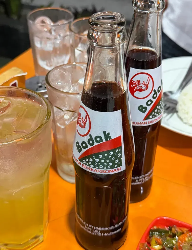 Sarsaparilla Cap Badak dan es jeruk di meja